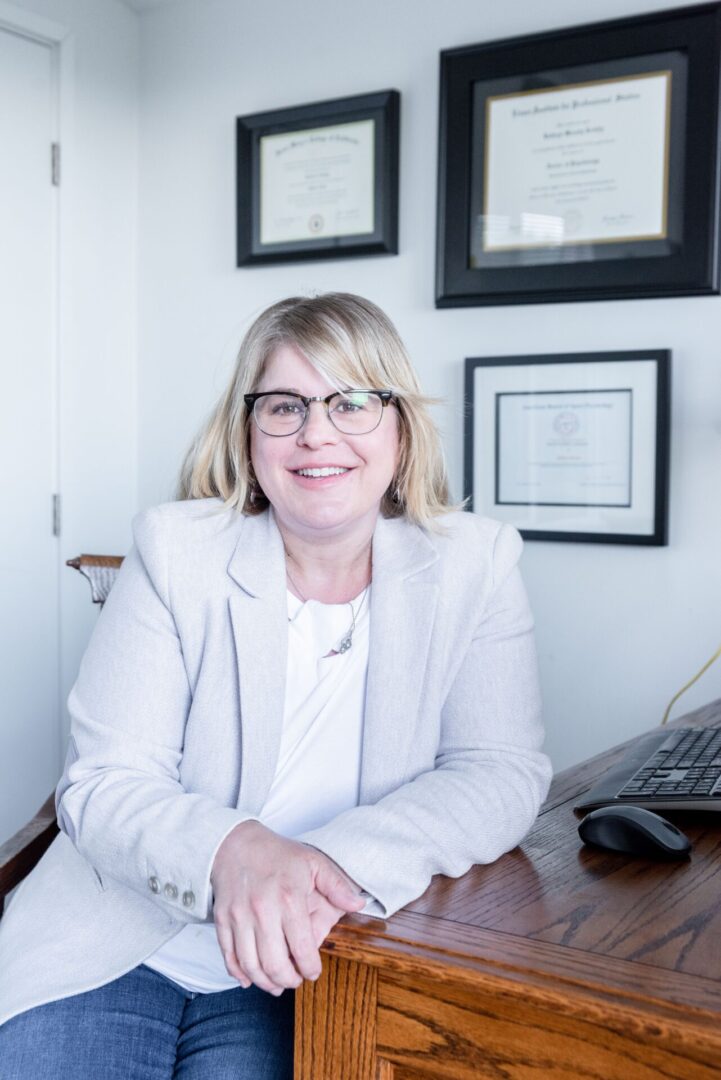 blonde psychologist with glasses wearing suit and white shirt